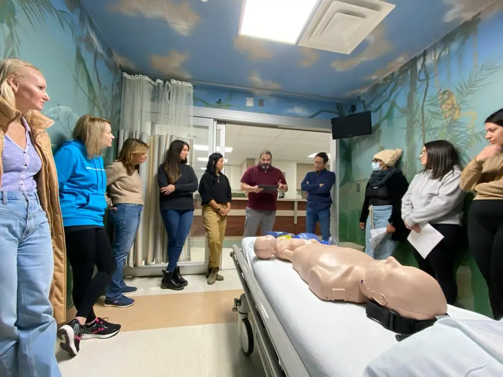 Healthcare professionals participating in hands on ACLS training scenario with simulation manikin