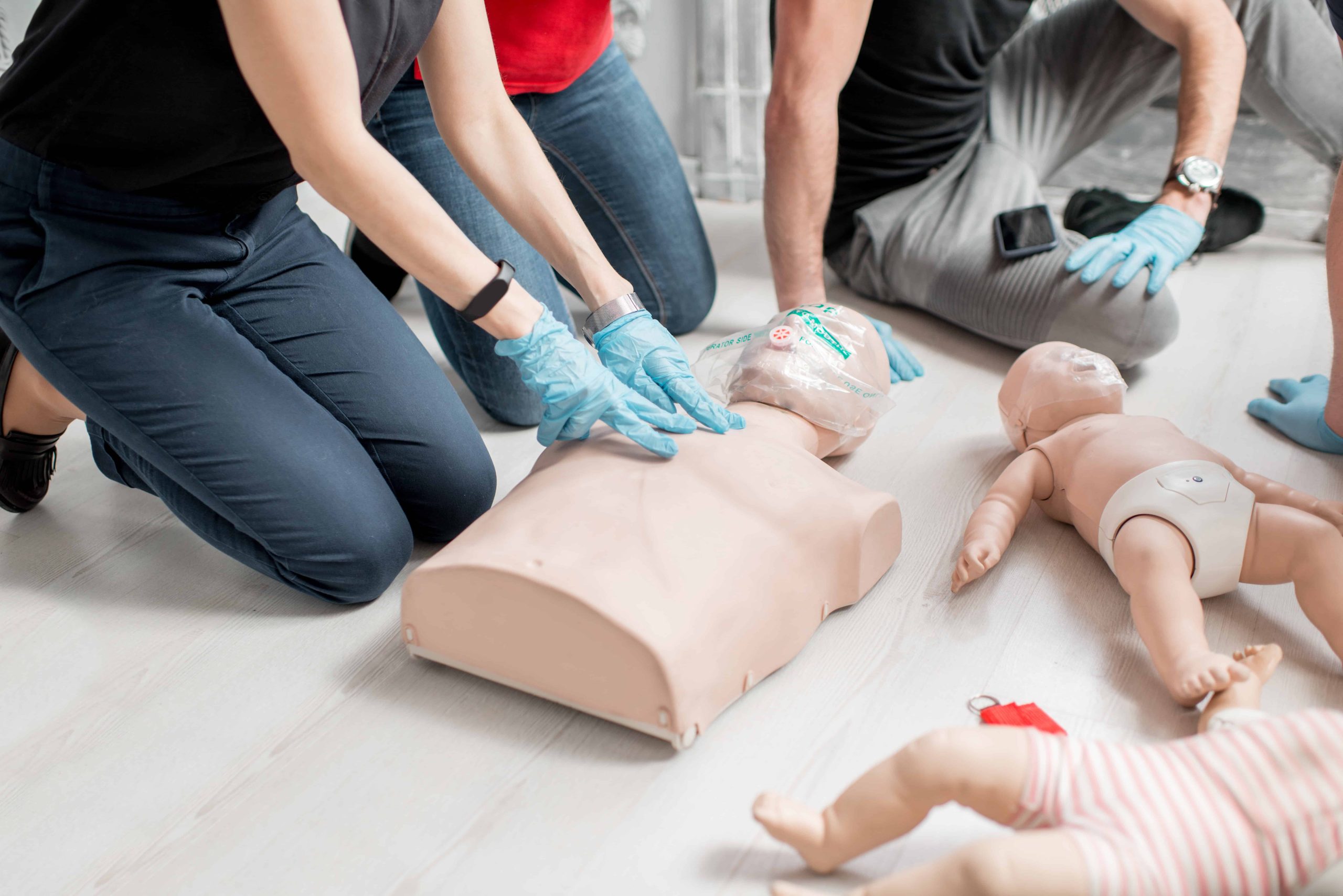 PALS Training with healthcare professionals practicing CPR on adult and infant manikins
