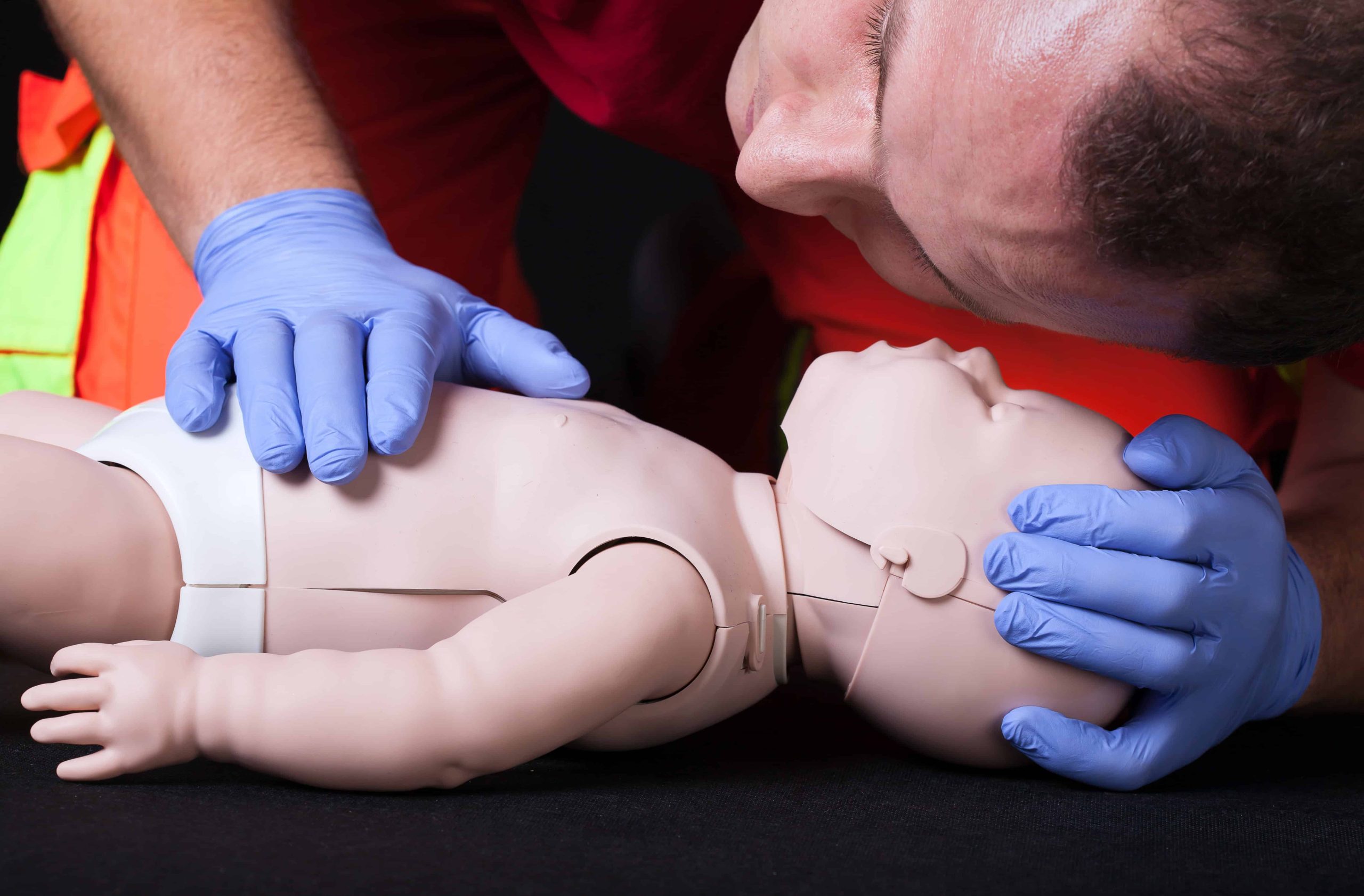 PALS Training participant practicing airway assessment on an infant mannequin