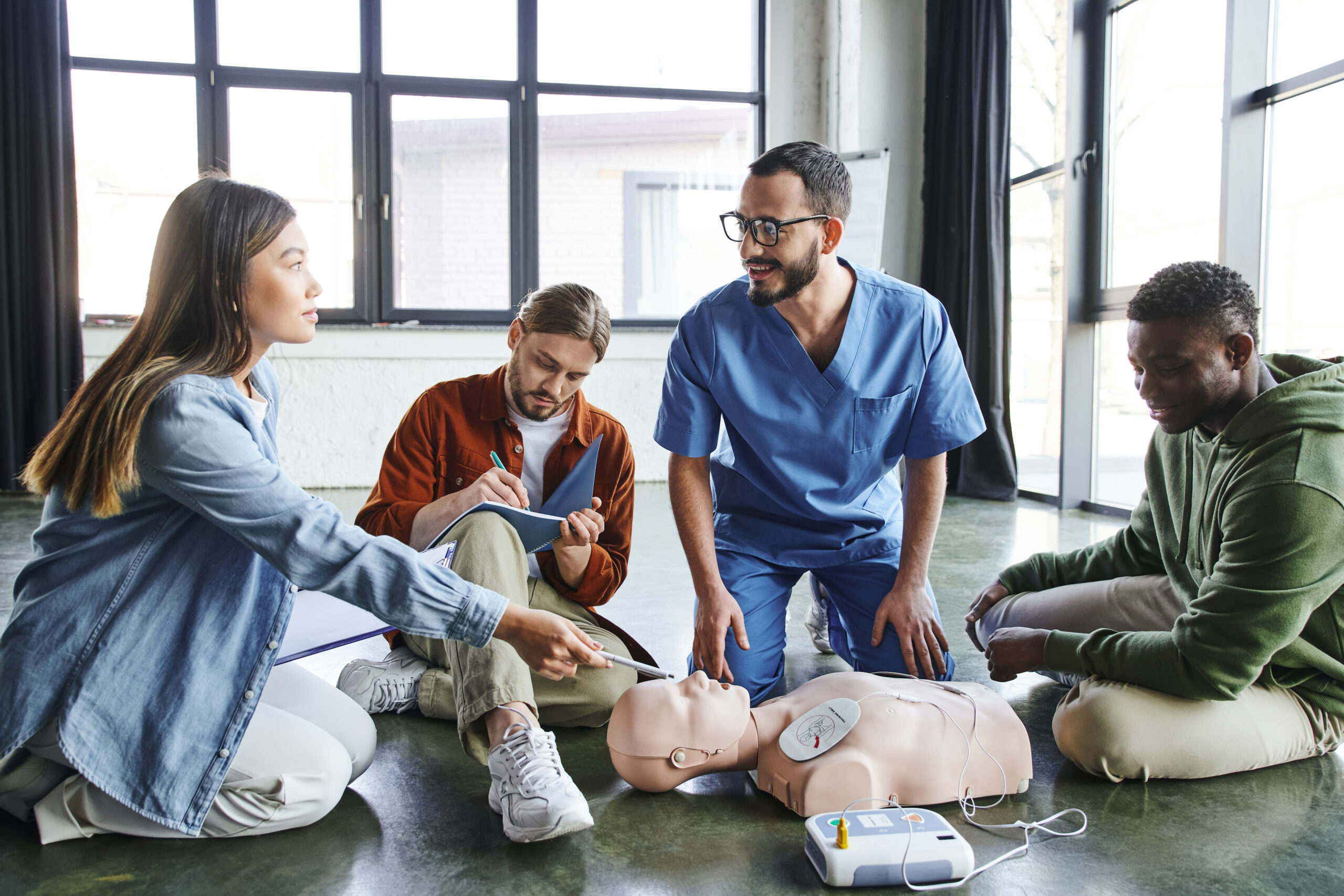 ACLS Training class with participants practicing lifesaving CPR skills on an adult manikin