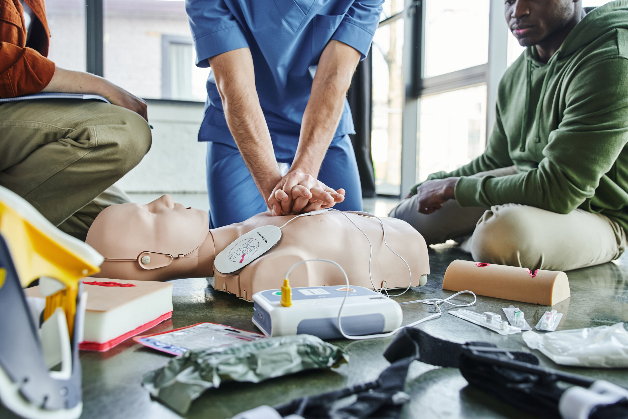 ACLS Training for healthcare professionals practicing CPR and defibrillation skills on a manikin