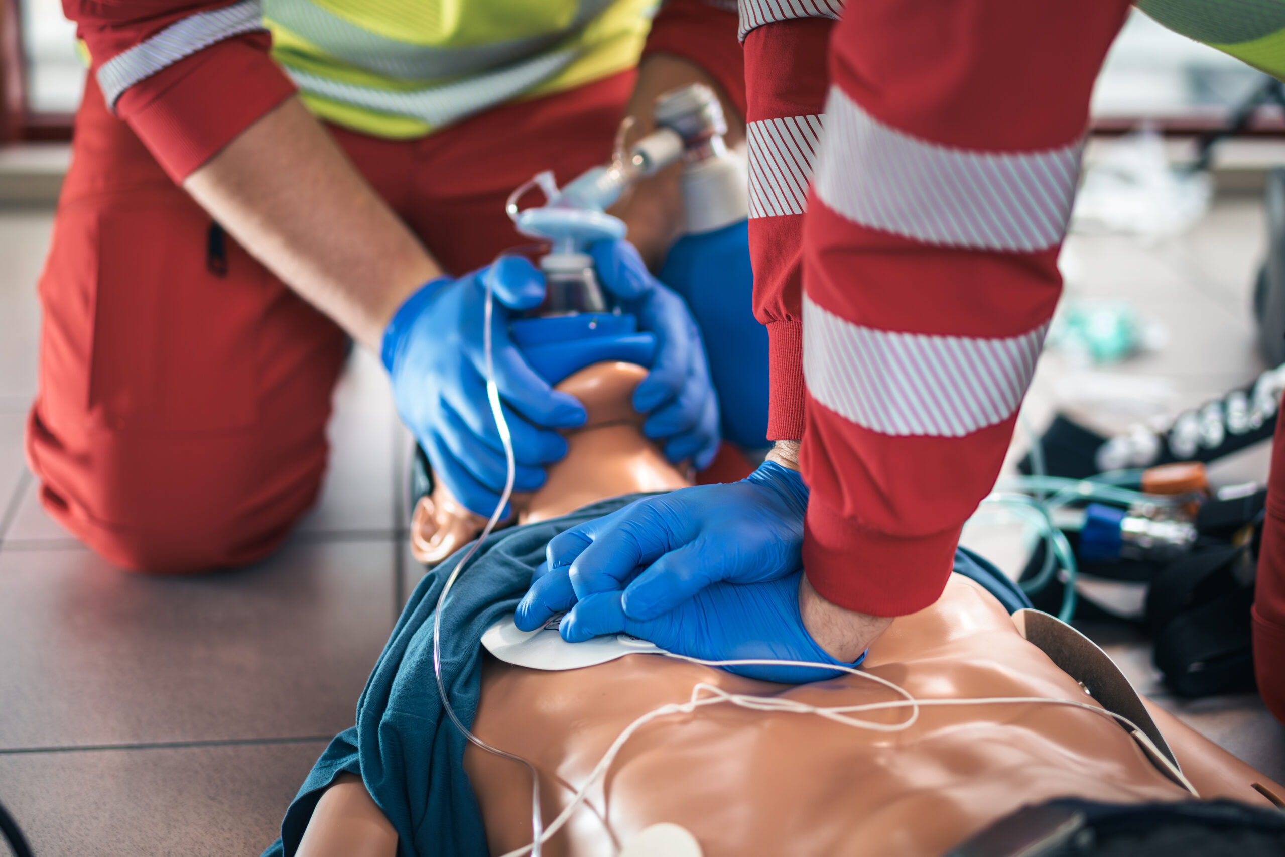 ACLS Training simulation with healthcare professionals practicing CPR, airway management, and cardiac resuscitation